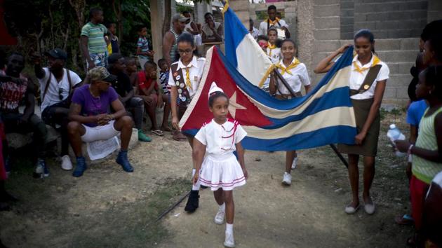 Girls parade a Cuban flag during the opening ceremony for the week-long student wrestling championship. Cuban sporting efforts have been entirely state-run, with talented children entering government programs early and spending their young adult lives in the arms of an official program that focuses their every minute on athletic glory. (Ramon Espinosa / AP) Girls parade a Cuban flag during the opening ceremony for the week-long student wrestling championship. Cuban sporting efforts have been entirely state-run, with talented children entering government programs early and spending their young adult lives in the arms of an official program that focuses their every minute on athletic glory. (Ramon Espinosa / AP)