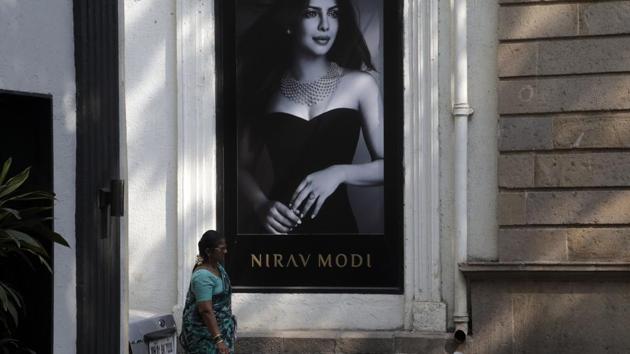 A woman walks past a Nirav Modi jewellery boutique, that displays a black and white photograph of actress Priyanka Chopra in Mumbai.(AP)