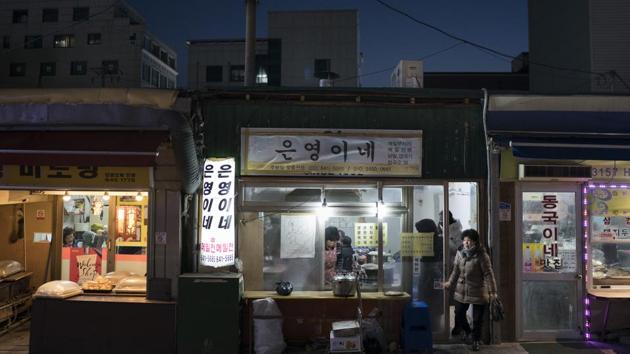 A woman leaves a restaurant in Gangneung, South Korea. Markets in South Korea can range in size from simple gatherings held every five days or so in some rural areas to the massive Namdaemun market area in Seoul, which houses more than 10,000 stores selling anything from fur coats to sneakers to deep-fried shrimp balls. (Felipe Dana / AP) A woman leaves a restaurant in Gangneung, South Korea. Markets in South Korea can range in size from simple gatherings held every five days or so in some rural areas to the massive Namdaemun market area in Seoul, which houses more than 10,000 stores selling anything from fur coats to sneakers to deep-fried shrimp balls. (Felipe Dana / AP)