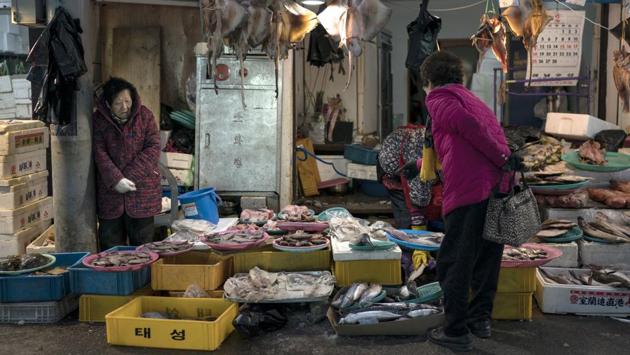 A woman shopping for fish scans through a vendor’s offerings. This part of the Pyeongchang area has for the most part escaped being Westernized and beautified for the Olympic Games. These blocks of street stalls are operated for the most part by old women who are decidedly no-nonsense about selling their wares. (Felipe Dana / AP) A woman shopping for fish scans through a vendor’s offerings. This part of the Pyeongchang area has for the most part escaped being Westernized and beautified for the Olympic Games. These blocks of street stalls are operated for the most part by old women who are decidedly no-nonsense about selling their wares. (Felipe Dana / AP)