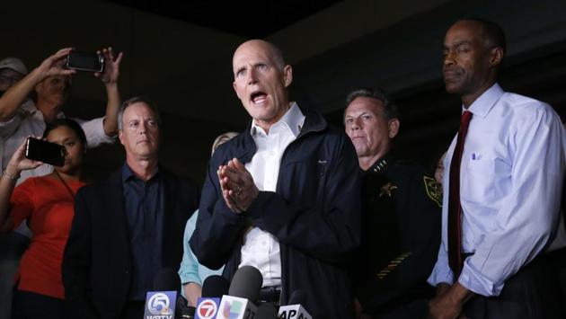 Florida Gov. Rick Scott (C) joined law enforcement agents near the site of the deadly school shooting and offered his condolences to the victims’ families and survivors. He said the attack that claimed at least 17 lives “is just absolutely pure evil.” (Wilfredo Lee / AP) 