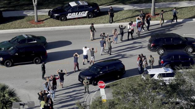 Students hold their hands in the air as they are evacuated by police from Marjory Stoneman Douglas High School in Parkland. The shooting took place in Parkland city, a middle-class community about 72km north of Miami, at around 2:30pm, just minutes before the close of school. (Mike Stocker/South Florida Sun-Sentinel via AP) 