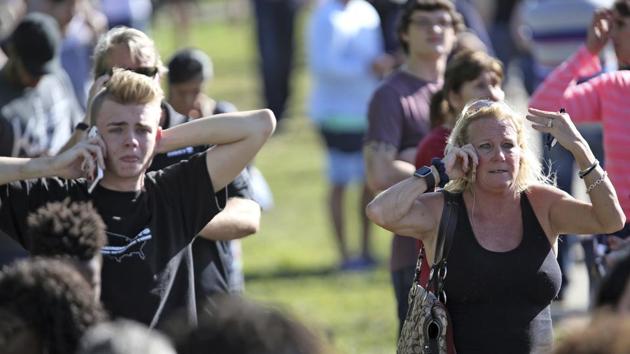 Waiting for word from students, anxious family members gather at Coral Springs Drive and the Sawgrass Expressway, just south of the campus. Witnesses and local leaders briefed by investigators indicated the assailant had planned the shooting meticulously with the intention to maximise casualties. He came wearing a gas mask and was carrying smoke grenades. (Amy Beth Bennett/South Florida Sun-Sentinel via AP) 