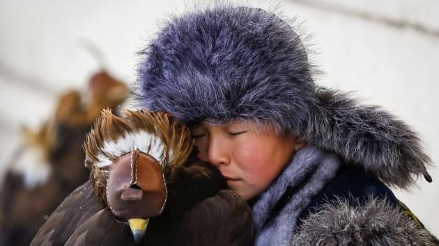A young hunter rests next to his tamed golden eagle during an annual hunters’ competition at Almaty hippodrome, Kazakhstan. (Shamil Zhumatov / REUTERS) A young hunter rests next to his tamed golden eagle during an annual hunters’ competition at Almaty hippodrome, Kazakhstan. (Shamil Zhumatov / REUTERS)