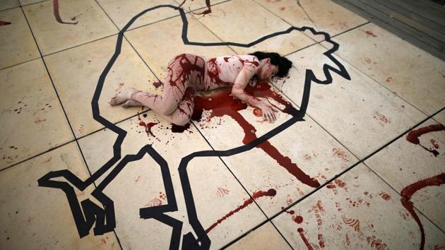 An Israeli activist from the Anonymous for Animal Rights group lies on the ground covered in artificial blood inside the outline of a chicken to resemble a crime scene in the centre of Tel Aviv, against animal slaughter. (Menahem Kahana / AFP) An Israeli activist from the Anonymous for Animal Rights group lies on the ground covered in artificial blood inside the outline of a chicken to resemble a crime scene in the centre of Tel Aviv, against animal slaughter. (Menahem Kahana / AFP)