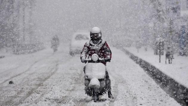 A man rides a scooter as it snows in Srinagar on February 12. Snowfall in Kashmir snapped links with the rest of the country as the arterial Jammu-Srinagar National Highway was closed due to the accumulation of snow around Jawahar Tunnel in the Qazigund area. (Waseem Andrabi / HT Photo) A man rides a scooter as it snows in Srinagar on February 12. Snowfall in Kashmir snapped links with the rest of the country as the arterial Jammu-Srinagar National Highway was closed due to the accumulation of snow around Jawahar Tunnel in the Qazigund area. (Waseem Andrabi / HT Photo)