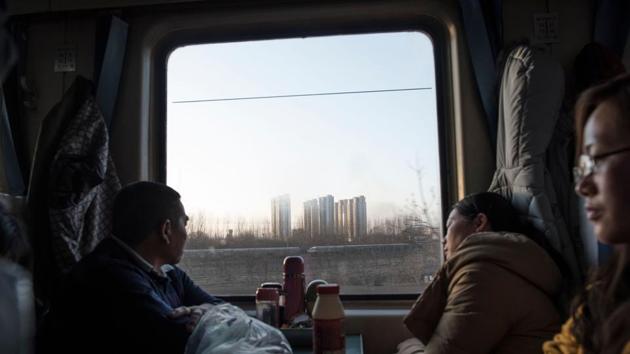 Passengers on a crowded train gaze out as it leaves Beijing for the 26-hour journey to Chengdu ahead of the Lunar New Year. Many among the millions of migrants headed to hometowns for the holidays won’t be returning due to policies that the Beijing government calls economic upgrading. (Fred Dufour / AFP) Passengers on a crowded train gaze out as it leaves Beijing for the 26-hour journey to Chengdu ahead of the Lunar New Year. Many among the millions of migrants headed to hometowns for the holidays won’t be returning due to policies that the Beijing government calls economic upgrading. (Fred Dufour / AFP)