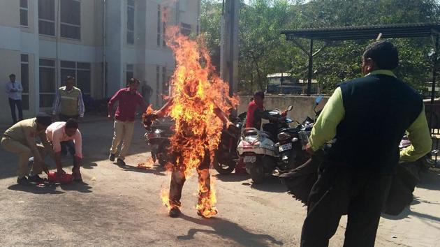 Police officials attempt to save Bhanubhai Vankar, who set himself on fire outside the Patan district collector's office on February 15. Vankar set himself on fire alleging delay in the handing over of a piece of land allotted to him under a government scheme. (AFP) Police officials attempt to save Bhanubhai Vankar, who set himself on fire outside the Patan district collector's office on February 15. Vankar set himself on fire alleging delay in the handing over of a piece of land allotted to him under a government scheme. (AFP)