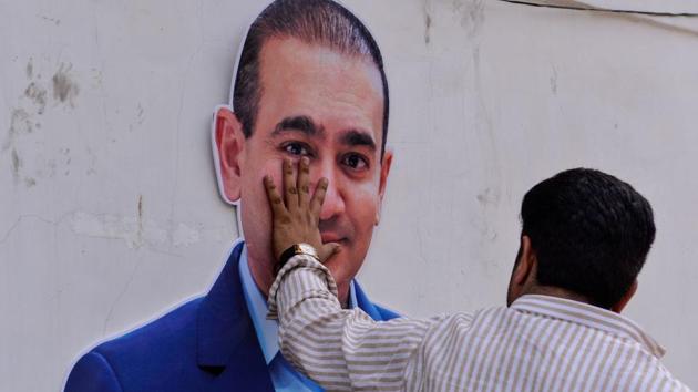 A Congress supporter keeps his hand on the face of a cut-out of billionaire jeweller Nirav Modi during a protest in New Delhi on February 16. (AFP Photo) A Congress supporter keeps his hand on the face of a cut-out of billionaire jeweller Nirav Modi during a protest in New Delhi on February 16. (AFP Photo)