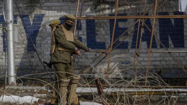 A policeman uses barbed wire to close a road leading towards the site of a gun battle in Srinagar.(AP File Photo)