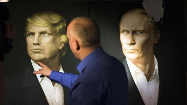 A journalist stands in front of the portraits of US President Donald Trump Russian President Vladimir Putin during a live telecast of the presidential election in the Union Jack pub in Moscow, Russia.(AP File Photo)