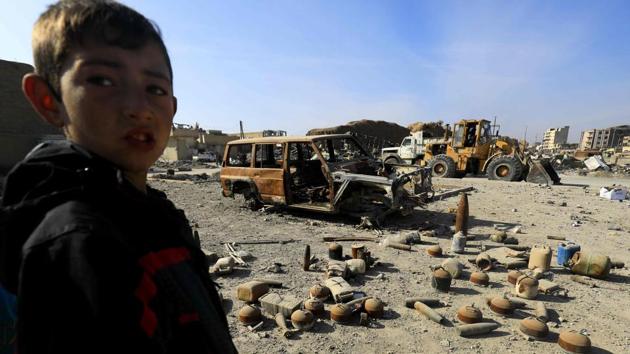 A Syrian boy stands near shells and undetonated mines lying on a street in Raqa that were left by the Islamic State (IS) group. (AFP) A Syrian boy stands near shells and undetonated mines lying on a street in Raqa that were left by the Islamic State (IS) group. (AFP)