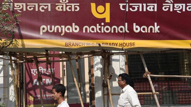 Men walk past Punjab National Bank (PNB) in Mumbai on February 14.(AFP File Photo)