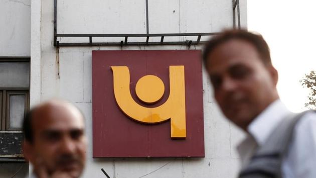People stand in front of the logo of Punjab National Bank outside a branch of the bank in New Delhi on February 15. (Reuters Photo) People stand in front of the logo of Punjab National Bank outside a branch of the bank in New Delhi on February 15. (Reuters Photo)