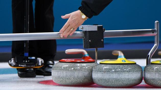 A judge measures during the women's curling round robin session between the Olympic Athletes from Russia and Switzerland during the Pyeongchang 2018 Winter Olympic Games at the Gangneung Curling Centre in Gangneung on February 19, 2018. (AFP) A judge measures during the women's curling round robin session between the Olympic Athletes from Russia and Switzerland during the Pyeongchang 2018 Winter Olympic Games at the Gangneung Curling Centre in Gangneung on February 19, 2018. (AFP)