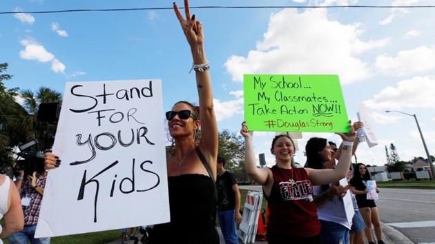 Lisa Madonna (L) joins Angelina Lazo (C), an 18-year-old senior at Marjory Stoneman Douglas High School, and other parents and students at a demonstration calling for more gun control at an intersection near the school, in Coral Springs, Florida, on February 18. (REUTERS) Lisa Madonna (L) joins Angelina Lazo (C), an 18-year-old senior at Marjory Stoneman Douglas High School, and other parents and students at a demonstration calling for more gun control at an intersection near the school, in Coral Springs, Florida, on February 18. (REUTERS)