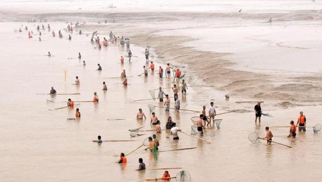 People fish along the bank of the Yellow River as the Sammenxia Dam discharges flood waters downstream, in Pinglu, Shanxi province. (Reuters File Photo) People fish along the bank of the Yellow River as the Sammenxia Dam discharges flood waters downstream, in Pinglu, Shanxi province. (Reuters File Photo)