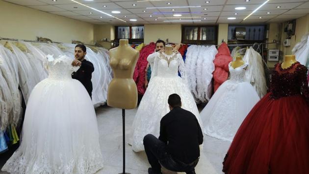 A picture taken on January 8, 2018 shows Syrian men arranging dresses at a wedding dresses shop in the capital Damascus. (AFP File Photo) A picture taken on January 8, 2018 shows Syrian men arranging dresses at a wedding dresses shop in the capital Damascus. (AFP File Photo)