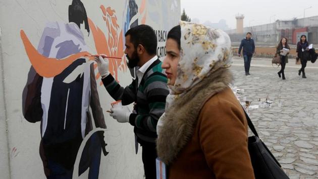 Afghan Artlords paint a message on a wall in Kabul. (REUTERS) Afghan Artlords paint a message on a wall in Kabul. (REUTERS)