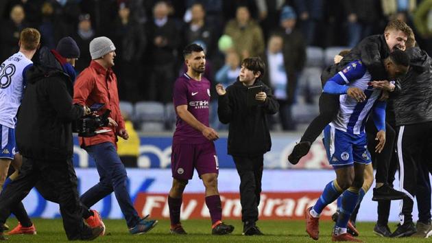 Manchester City's Argentinian striker Sergio Aguero (C) walks as supporters invade the pitch after the English FA Cup fifth round football match against Wigan Athletic at the DW Stadium in Wigan on Monday. (AFP) Manchester City's Argentinian striker Sergio Aguero (C) walks as supporters invade the pitch after the English FA Cup fifth round football match against Wigan Athletic at the DW Stadium in Wigan on Monday. (AFP)