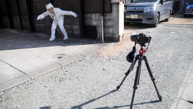 Nishimoto slips into her dog costume chained to a post in her garden to take photos of herself. She only took up photography aged 72, quickly became hooked on the hobby after being invited to join a local class. Closing in on her 90th birthday, she has amassed more than 41,000 followers in just two months since she started posting her hilarious snaps on Instagram. (Behrouz Mehri / AFP File Photo) Nishimoto slips into her dog costume chained to a post in her garden to take photos of herself. She only took up photography aged 72, quickly became hooked on the hobby after being invited to join a local class. Closing in on her 90th birthday, she has amassed more than 41,000 followers in just two months since she started posting her hilarious snaps on Instagram. (Behrouz Mehri / AFP File Photo)
