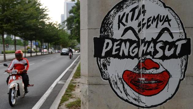 A motorcyclist riding past a poster depicting a clown-faced caricature of Malaysian Prime Minister Najib Razak in Kuala Lumpur in this photo taken on March 21, 2016. (AFP File Photo) A motorcyclist riding past a poster depicting a clown-faced caricature of Malaysian Prime Minister Najib Razak in Kuala Lumpur in this photo taken on March 21, 2016. (AFP File Photo)