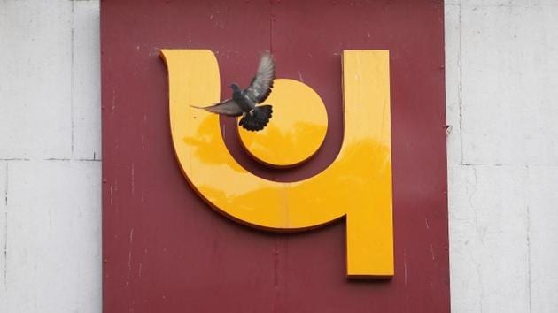 A pigeon flies past the logo of Punjab National Bank outside a branch of the bank in New Delhi.(REUTERS)