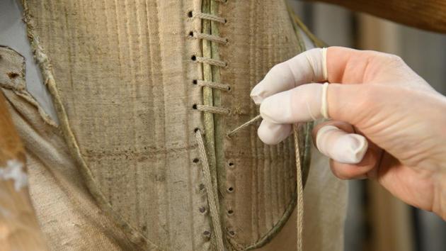 Costume historian Jenny Tiramani threads a loop-manipulated five-way plait during the fitting of a 'pair of straight bodies' to the funeral effigy of Elizabeth I at Westminster Abbey. (Leon Neal / Getty Images) 
