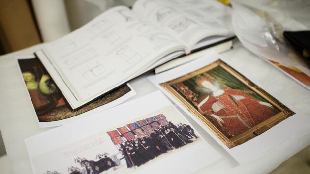 A copy of a painting of the funeral precession of Elizabeth I lies next to where the costume historian is at work.  (Leon Neal / Getty Images) 