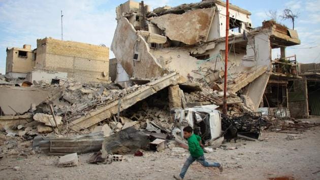 A Syrian boy runs past a destroyed building during air strikes by regime forces. The two main factions in Ghouta, which include Failaq al-Rahman, accuse Moscow and the Syrian army of breaching the de-escalation agreements. (Hamza Al-Ajweh / AFP)