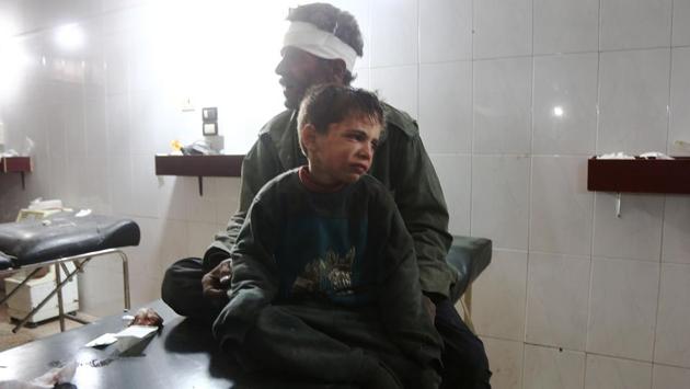 A Syrian child injured in the government bombing cries as he sits with his father at a makeshift hospital in Hamouria, Damascus. Neither the Syrian military nor Russia commented on the renewed bombardment , but they have often said they do not target civilians. (Abdulmonam Eassa / AFP)