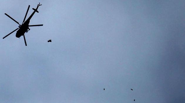 A Russian-made Syrian army helicopter is seen dropping a payload over the rebel-held town of Arbin. With the Islamic State (IS) losing key territories in Iraq and Syria last year, Russian-backed Syrian forces are making a major push to overrun the country’s remaining rebel strongholds. (Amer Almohibany / AFP)