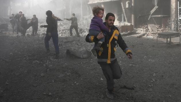 A Syrian man carries a child injured in government bombing in the rebel-held town of Hamouria, Damascus. The UN called for an immediate ceasefire in the area saying the situation was “spiralling out of control.” On Monday alone, 127 civilians, including 39 children, were killed in the bombardment - the single bloodiest day for Eastern Ghouta in four years. (Abdulmonam Eassa / AFP)