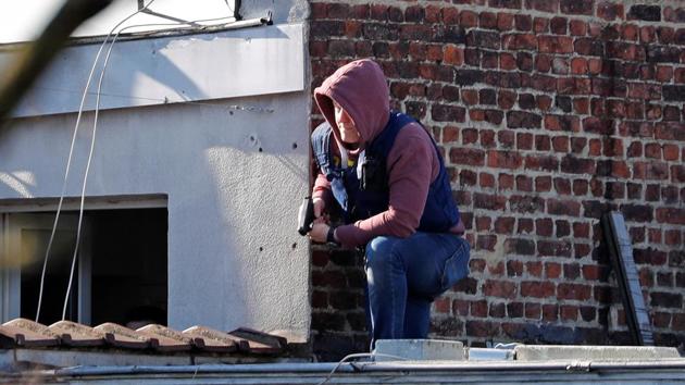 A Belgian police officer prepares his gun while taking position on a roof after an area of the Forest commune had been closed by Belgian police and special forces, in Brussels, Belgium. (Reuters) A Belgian police officer prepares his gun while taking position on a roof after an area of the Forest commune had been closed by Belgian police and special forces, in Brussels, Belgium. (Reuters)
