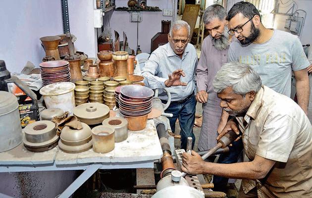 (From left) Bhalchandra Kadu explains the making of a copper glass to Asiam Bhatt and Imtiaz Kak at his workshop in Tambat Aali, Pune(RAVINDRA JOSHI/HT PHOTO)