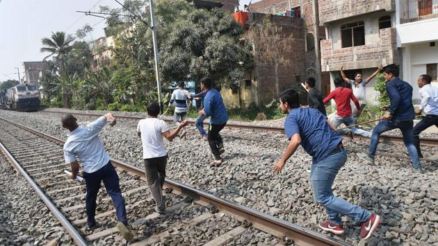 Agitating applicants throw stones on a train during a protest demanding for the removal of technical courses from Railway Group-D exams, in Patna on Thursday. (PTI) Agitating applicants throw stones on a train during a protest demanding for the removal of technical courses from Railway Group-D exams, in Patna on Thursday. (PTI)