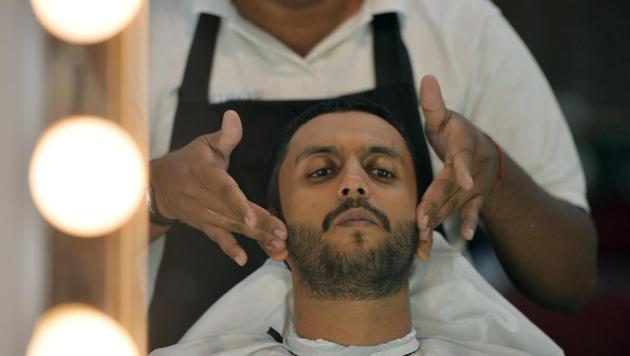 A male hairdresser working with a customer at a men's salon in Islamabad.(AFP)