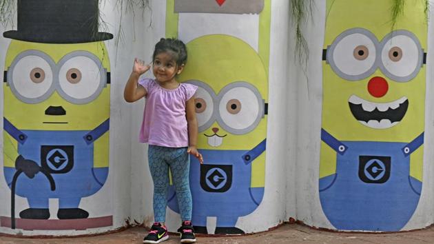 A girl asks her mother to take a photograph of her and her favourite cartoon characters. (Shashi S Kashyap/HT PHOTO) 