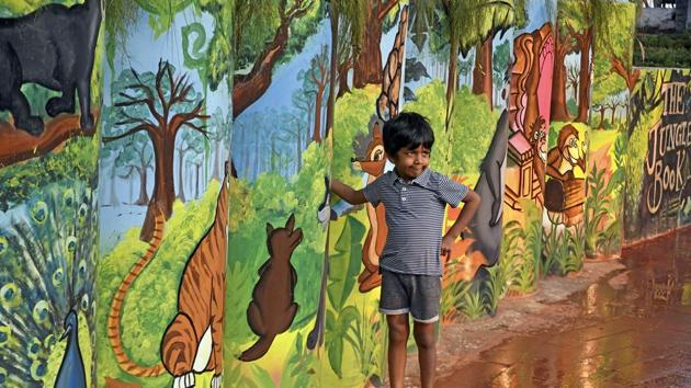 A boy poses against paintings of characters from The Jungle Book. (Shashi S Kashyap/HT) 