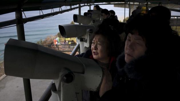 Visitors use binoculars to view North Korea from the Goseong Unification Observatory in South Korea. Parts of the North’s Diamond Mountain can be seen from here, where the two Koreas once ran a joint tourism project during a past era of detente. The project stalled after a North Korean soldier fatally shot a South Korean tourist visiting the mountain resort in 2008. (Jae C. Hong / AP) Visitors use binoculars to view North Korea from the Goseong Unification Observatory in South Korea. Parts of the North’s Diamond Mountain can be seen from here, where the two Koreas once ran a joint tourism project during a past era of detente. The project stalled after a North Korean soldier fatally shot a South Korean tourist visiting the mountain resort in 2008. (Jae C. Hong / AP)