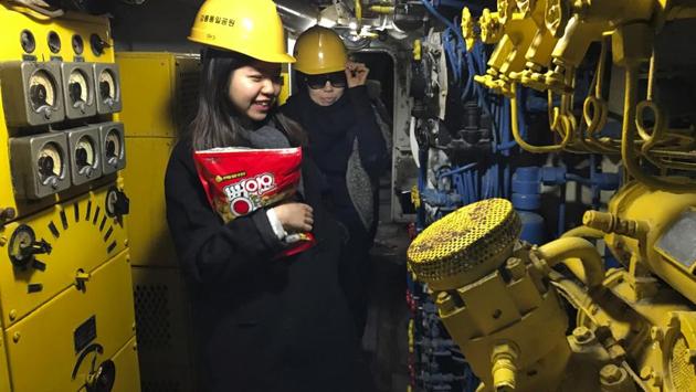 Visitors walk inside a North Korean submarine at the seaside ‘Unification Park’ in Gangneung, South Korea. A taxi driver detected the stranded submarine that ran aground in 1996 during a spying mission and reported it to South Korean authorities, triggering a 49-day manhunt that included shoot-outs with fleeing North Korean soldiers. Visitors are required to wear yellow safety helmets before entering the submarines cramped, low-ceilinged inside parts. (Jae C. Hong / AP) Visitors walk inside a North Korean submarine at the seaside ‘Unification Park’ in Gangneung, South Korea. A taxi driver detected the stranded submarine that ran aground in 1996 during a spying mission and reported it to South Korean authorities, triggering a 49-day manhunt that included shoot-outs with fleeing North Korean soldiers. Visitors are required to wear yellow safety helmets before entering the submarines cramped, low-ceilinged inside parts. (Jae C. Hong / AP)