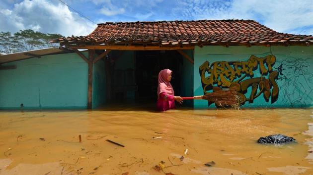 A villager cleans garbage in front of her house as flood hit the Tanjungsari village in Indonesia on February 23. (Adeng Bustomi / Antara Foto / REUTERS) A villager cleans garbage in front of her house as flood hit the Tanjungsari village in Indonesia on February 23. (Adeng Bustomi / Antara Foto / REUTERS)