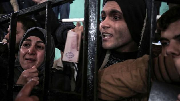 Palestinians wait for permission to cross into Egypt through the Rafah border crossing in the southern Gaza Strip after it was opened by Egyptian authorities on February 21. (Said Khatib / AFP) Palestinians wait for permission to cross into Egypt through the Rafah border crossing in the southern Gaza Strip after it was opened by Egyptian authorities on February 21. (Said Khatib / AFP)