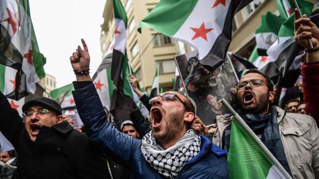 Protesters chant slogans and wave former Syrian independence flags (now adopted by forces fighting Syrian pro-government forces) in front of the Russian Consulate in Istanbul on February 22, 2018, during a protest against the airstrikes and shelling by Syrian government forces in Ghouta. (AFP Photo) Protesters chant slogans and wave former Syrian independence flags (now adopted by forces fighting Syrian pro-government forces) in front of the Russian Consulate in Istanbul on February 22, 2018, during a protest against the airstrikes and shelling by Syrian government forces in Ghouta. (AFP Photo)