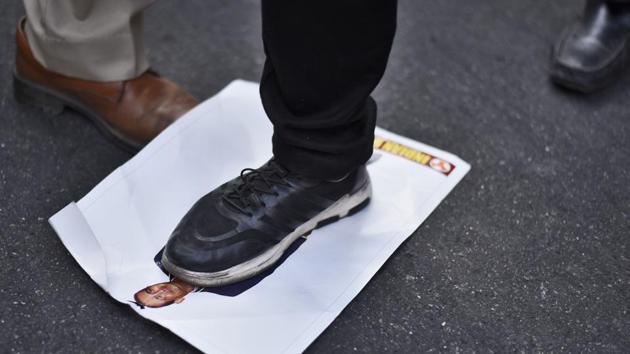 An Indian Youth Congress activist stands on a portrait of Nirav Modi during a protest at IYC office in New Delhi on February 21. (Burhaan Kinu / HT Photo)
