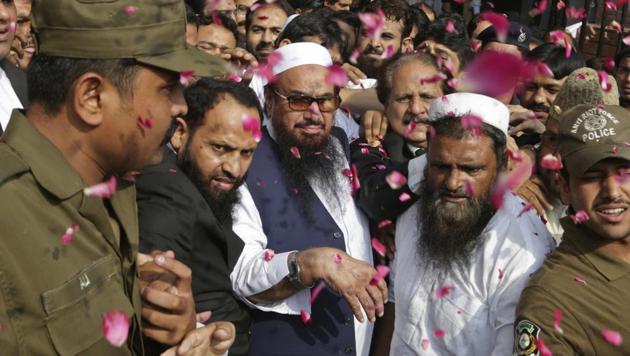In this file photo, supporters of Hafiz Saeed, centre, can be seen showering him with rose petals as he arrives to a court in Lahore. (AP) In this file photo, supporters of Hafiz Saeed, centre, can be seen showering him with rose petals as he arrives to a court in Lahore. (AP)