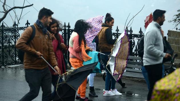 Tourists’ umbrellas turn inside-out due to strong winds on The Ridge in Shimla on Saturday. (Deepak sansta/ht)