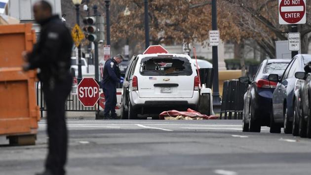 An agent inspects a passenger car sitting at a security barrier it struck near the White House in Washington, DC, on February 23, 2018. The US Secret Service is currently investigating the incident.(AFP)