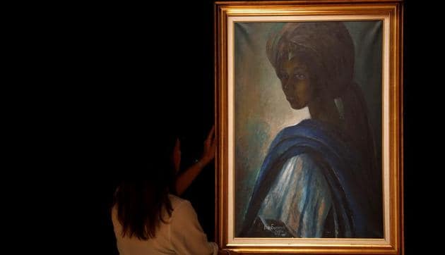 A worker at Bonhams auctioneers poses next to Tutu, by Nigeria's best-known modern artist Ben Enwonwu, ahead of its sale on February 28.(REUTERS/Peter Nicholls)