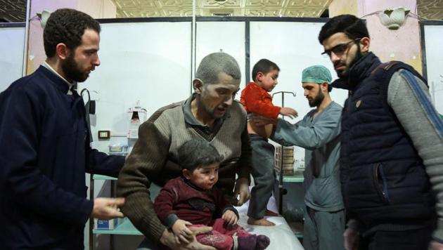 A Syrian man covered with dust from reported regime bombardment sits carrying a child as they are tended to by paramedics at a make-shift clinic in the rebel-held town of Douma, in the besieged Eastern Ghouta region on the outskirts of the capital Damascus, on February 24, 2018. (AFP Photo) A Syrian man covered with dust from reported regime bombardment sits carrying a child as they are tended to by paramedics at a make-shift clinic in the rebel-held town of Douma, in the besieged Eastern Ghouta region on the outskirts of the capital Damascus, on February 24, 2018. (AFP Photo)